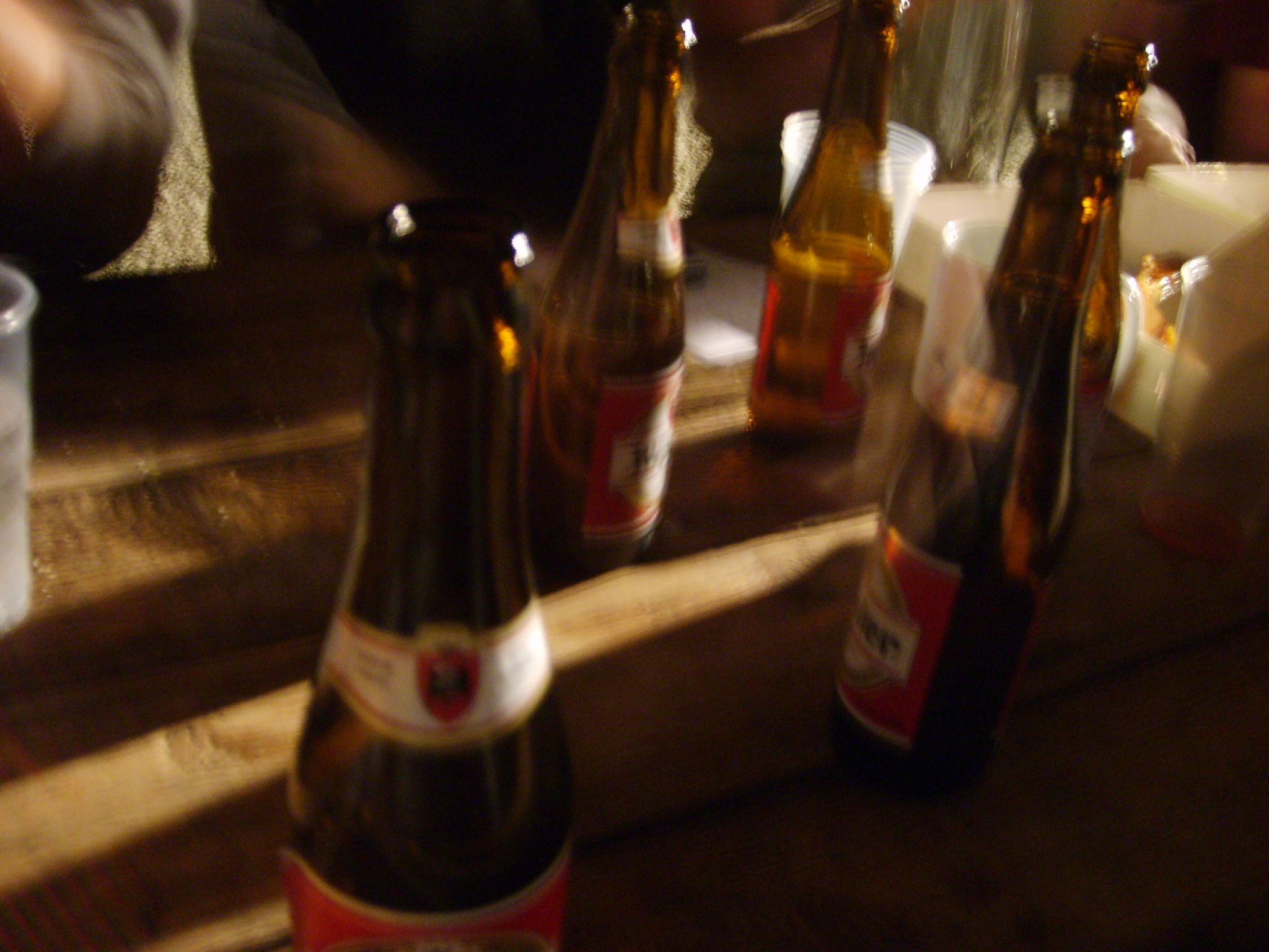 bottles of beer being served by three people