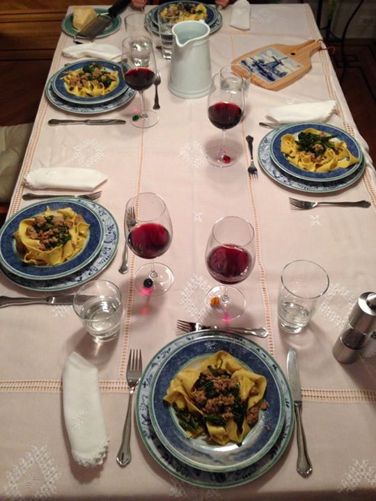 several plates with pasta and wine glasses are on the table