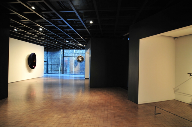 an empty room with three clocks hanging from the ceiling