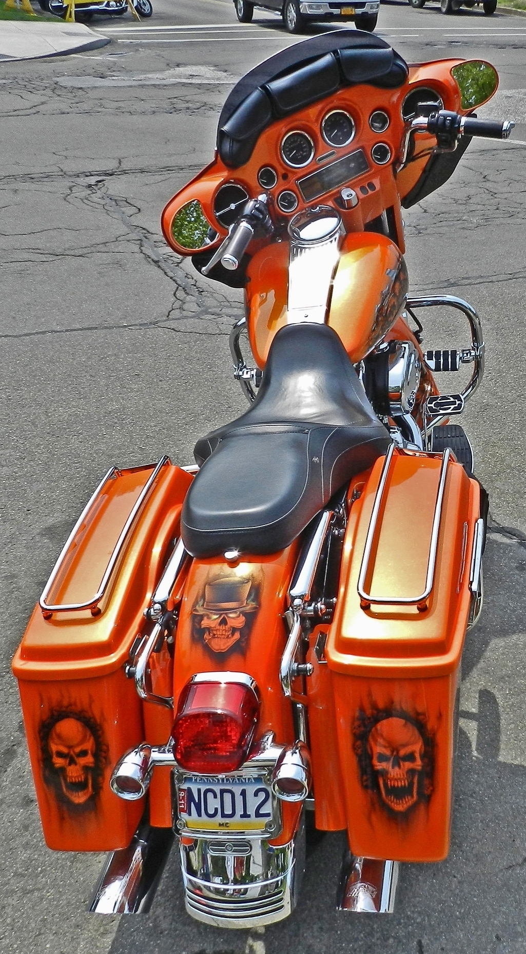 this motorcyle is designed in the colors of an orange with skulls