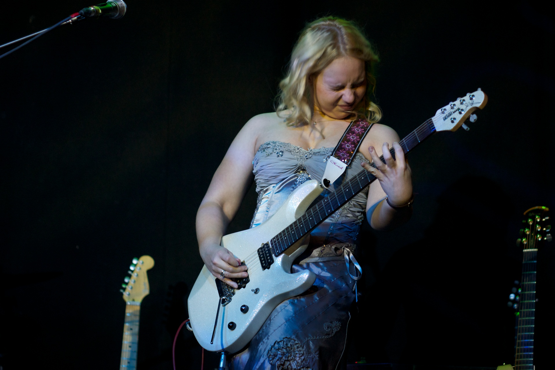 the girl has a guitar and other instruments in her hand