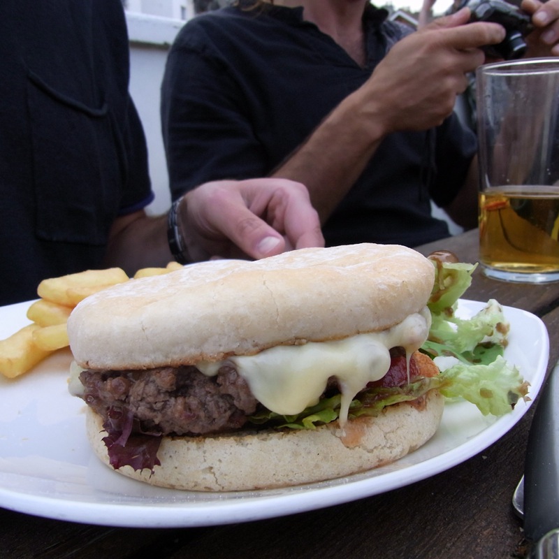 a close up of a hamburger on a plate with french fries