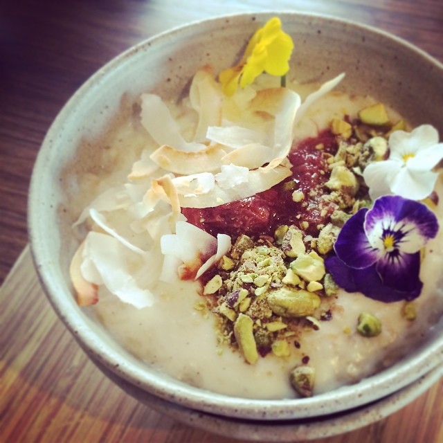 a bowl filled with oatmeal and fruit topped with flowers