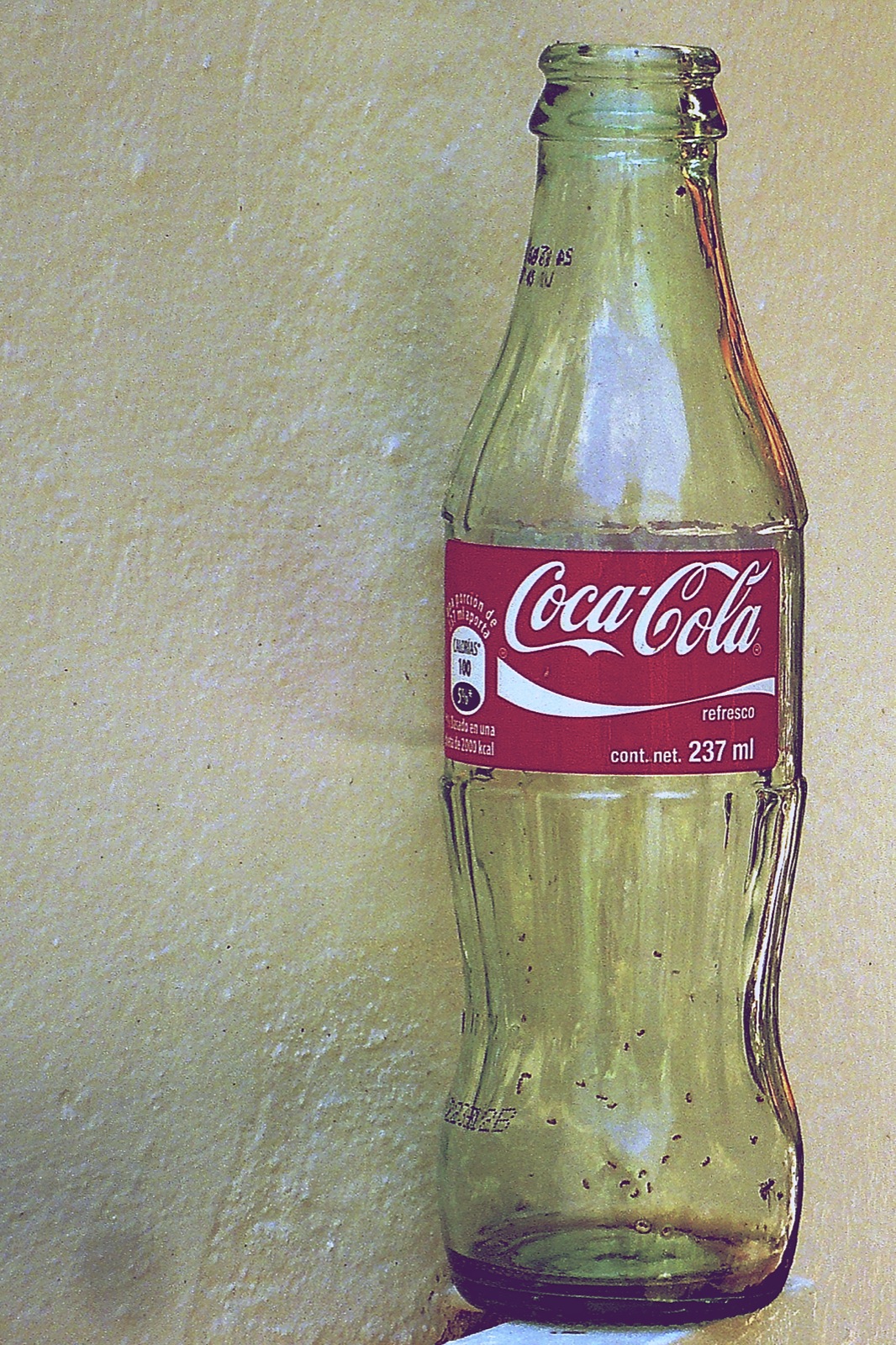 an open coke bottle on a table top