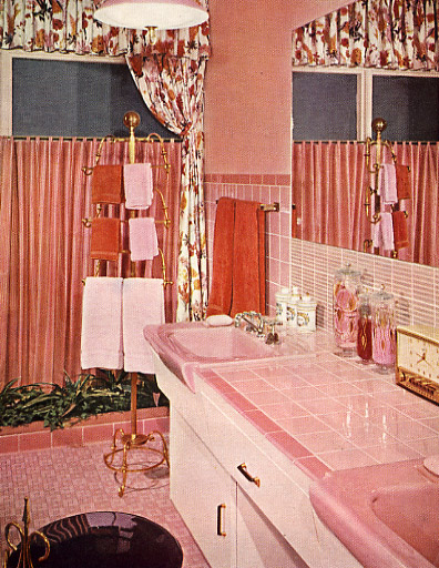 a pink bathroom with a lot of towels hanging on the window
