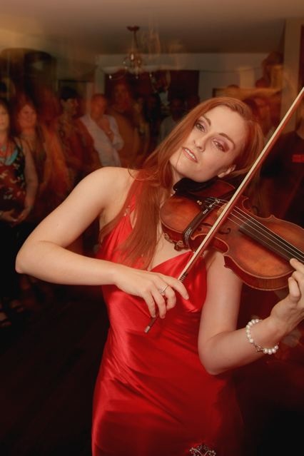 the girl is posing with her violin and posing for a picture