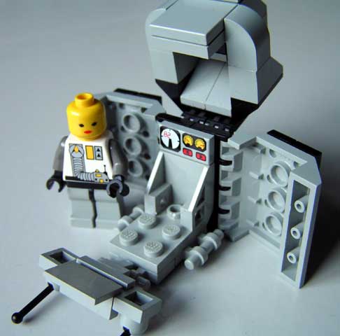 a lego robot is standing by a space station