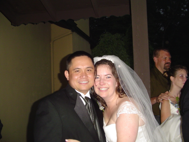 a man in a wedding suit hugging a woman on the cheek