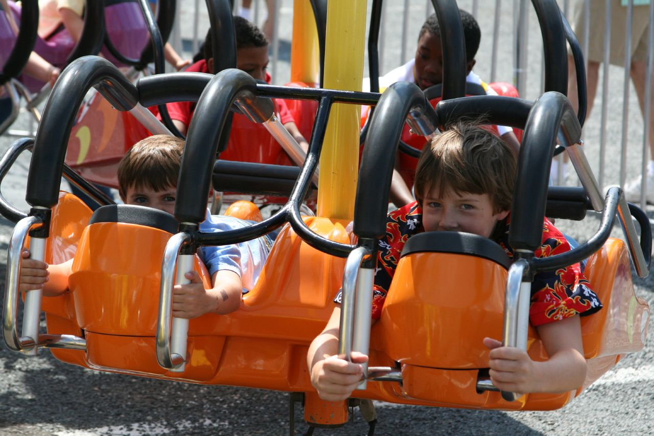 the two boys are in an orange car