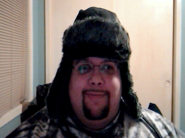 a man making a silly face while wearing a hat and scarf