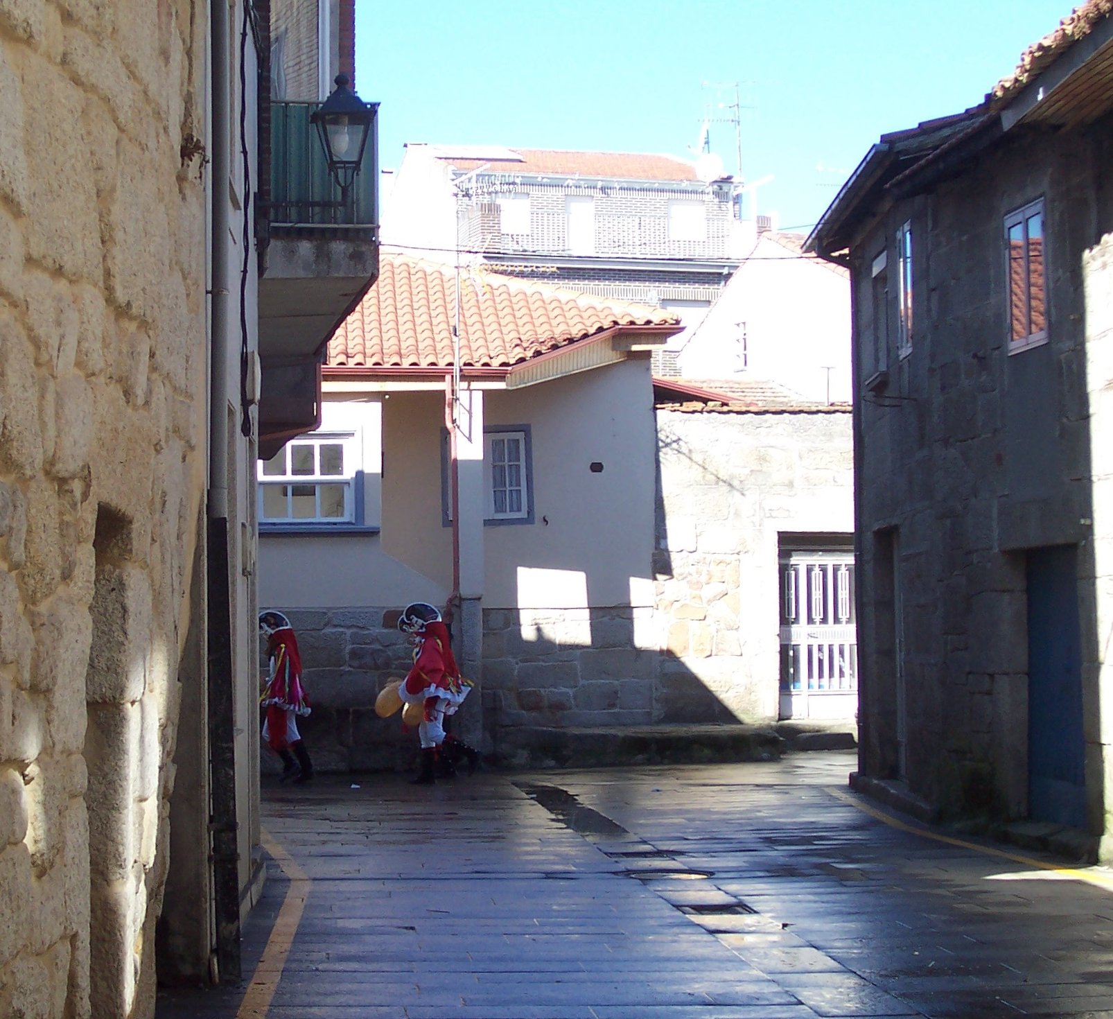 a narrow city street lined with lots of buildings
