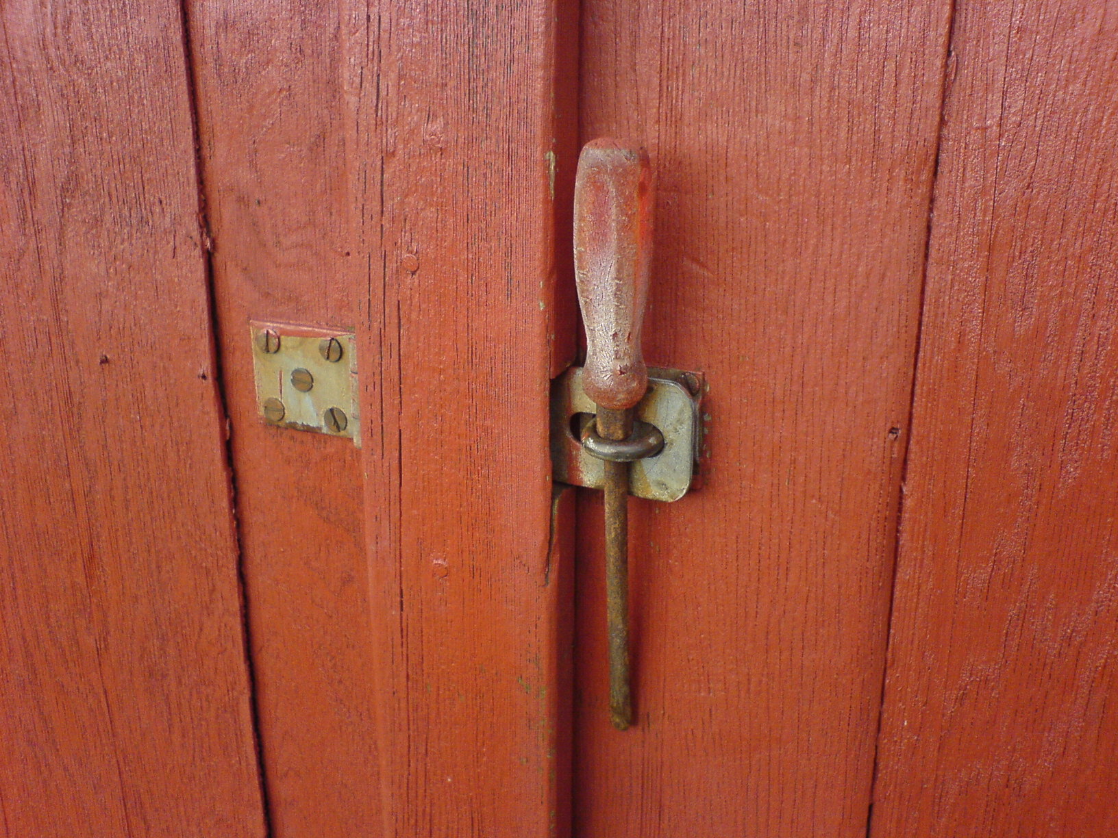 closeup of an old red door with a metal door handle