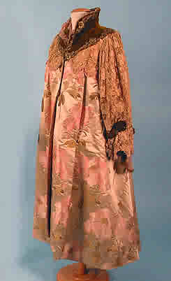 an elaborately embroidered gown and a cap on display