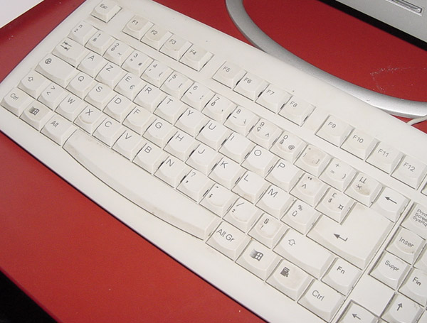 a wireless keyboard sits next to a computer monitor
