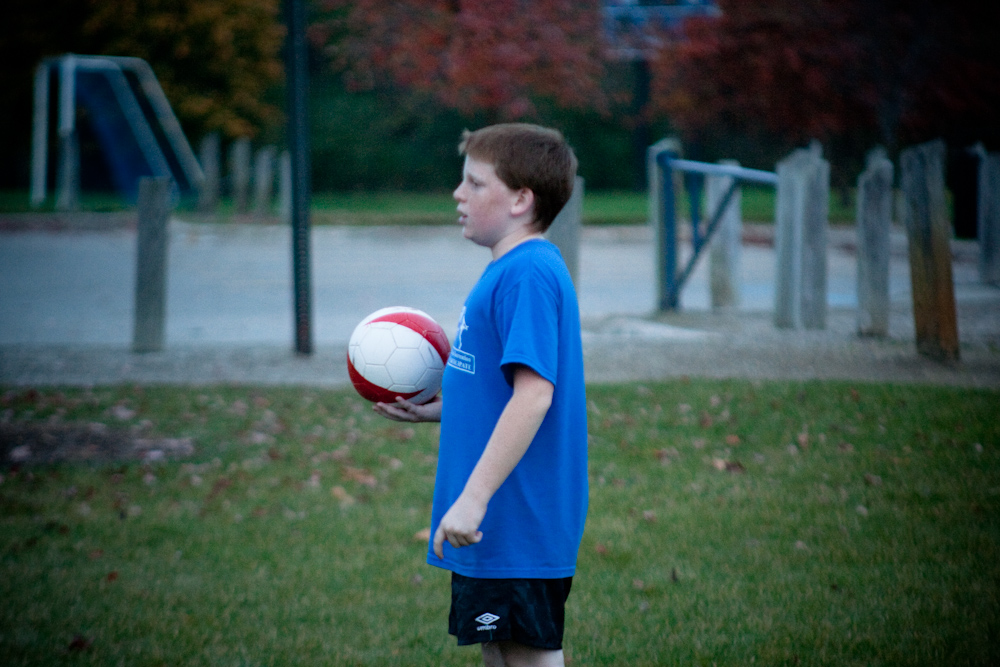 the  holds a soccer ball on a field