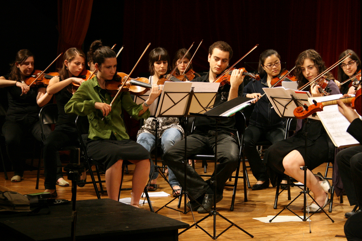 a orchestra with musicians on stage, playing musical instruments