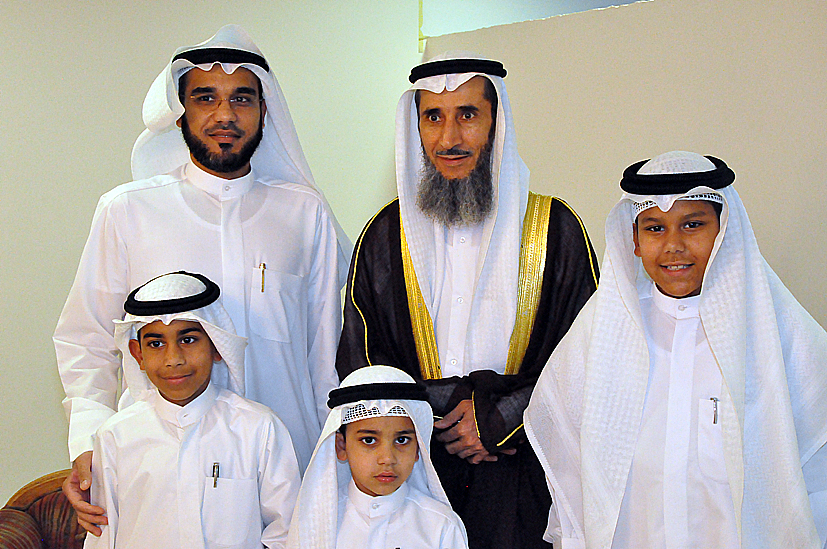 three adults and two children are posing for a picture