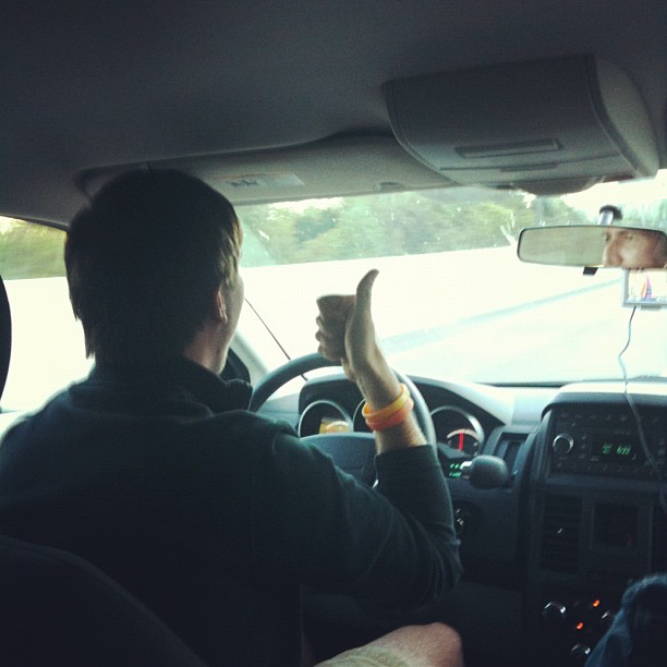 man sitting behind steering wheel and driving a car