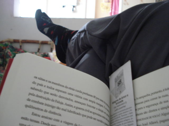 a person's legs reading a book while sitting on a couch