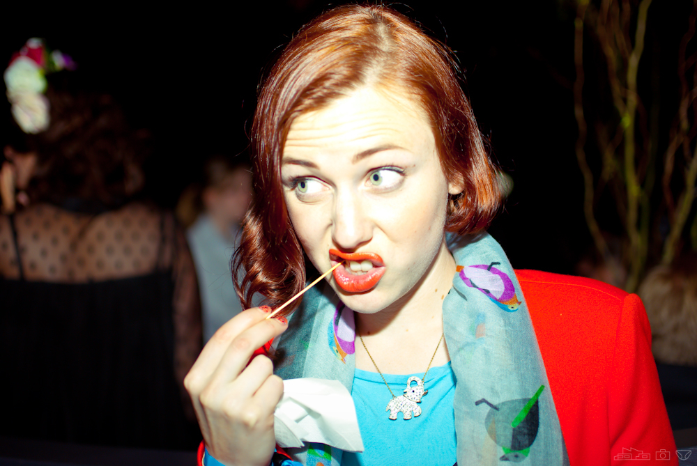 a woman with a red lip on a stick sticking out of her mouth