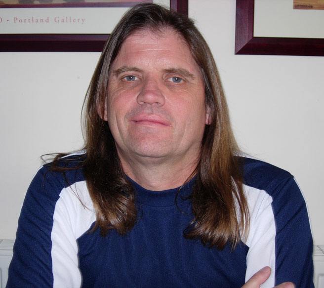 a man with long hair looks over his shoulder