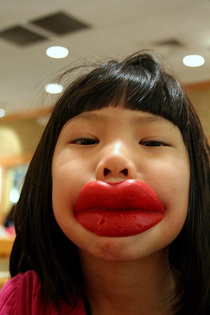 girl is making funny face with red lipstick