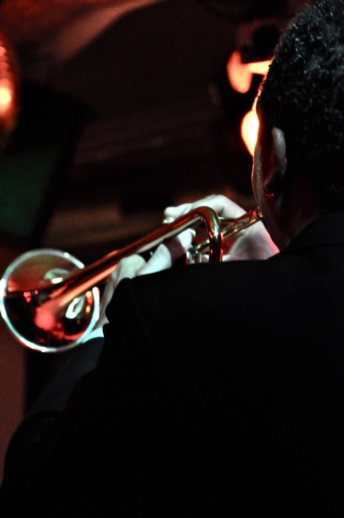a man in black suit playing the trombone