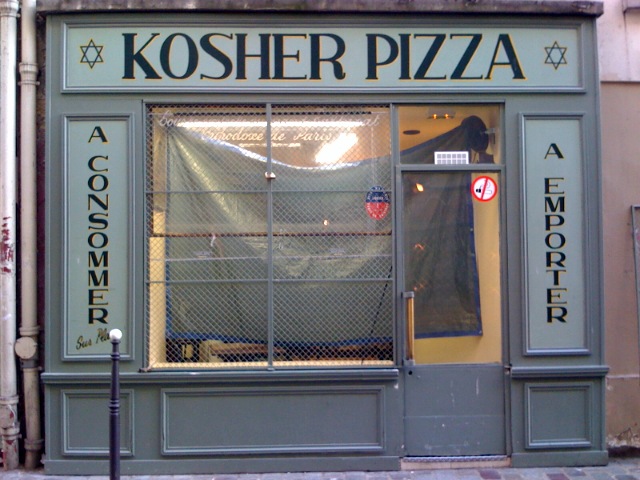 the front door of a small restaurant called kosher pizza