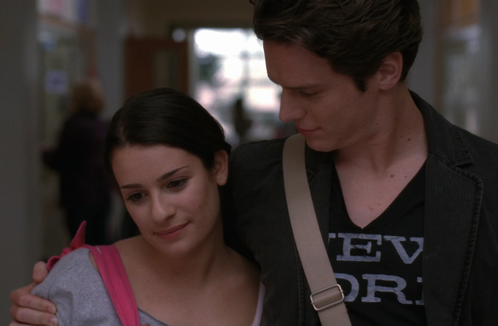 a young man and woman walking down a corridor