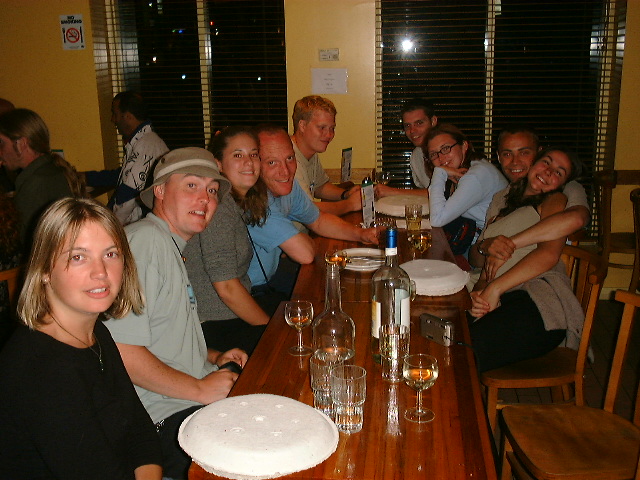 a group of people sitting at a table with plates and glasses in front of them