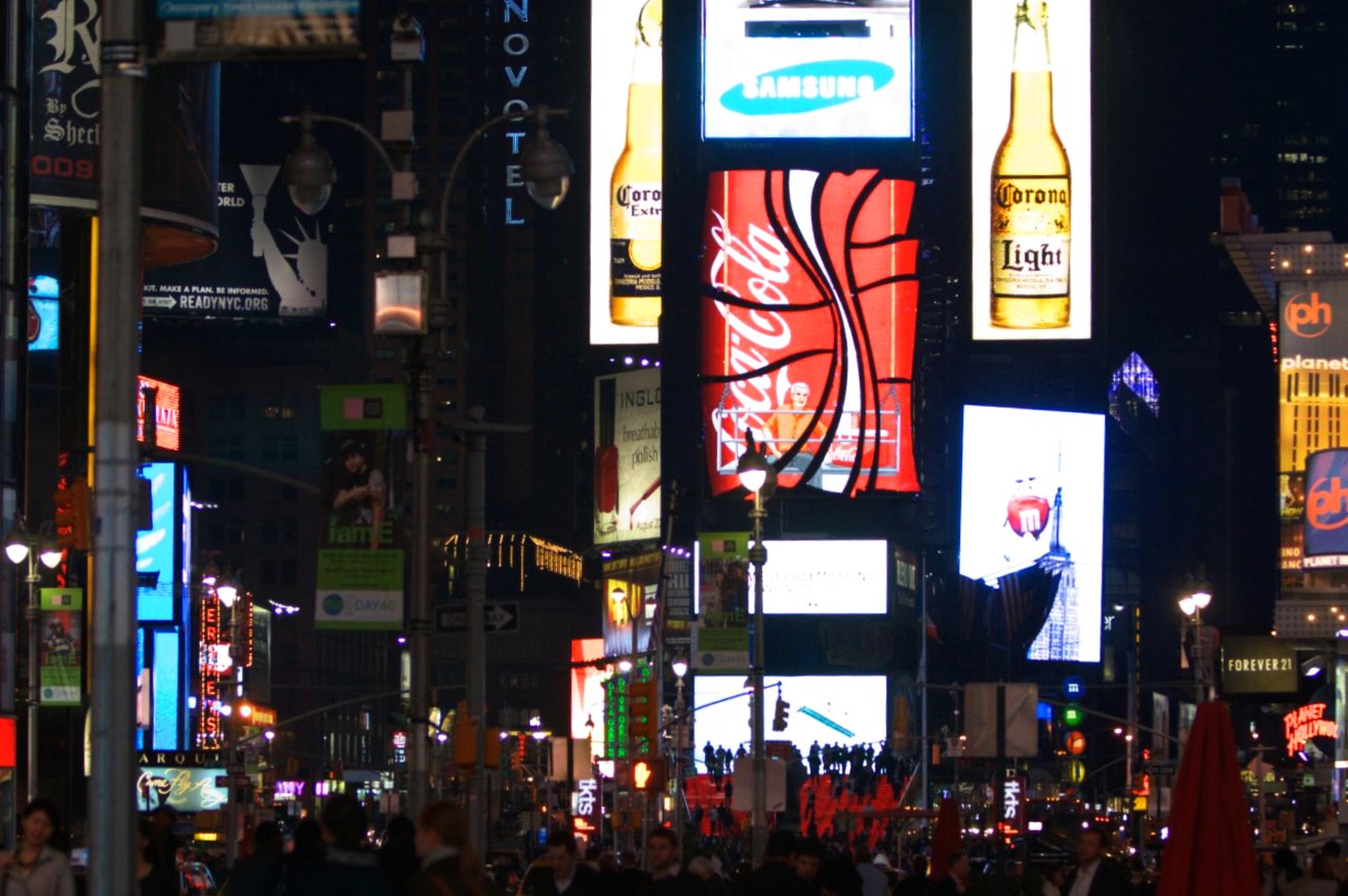 a busy street at night filled with lots of lights and billboards