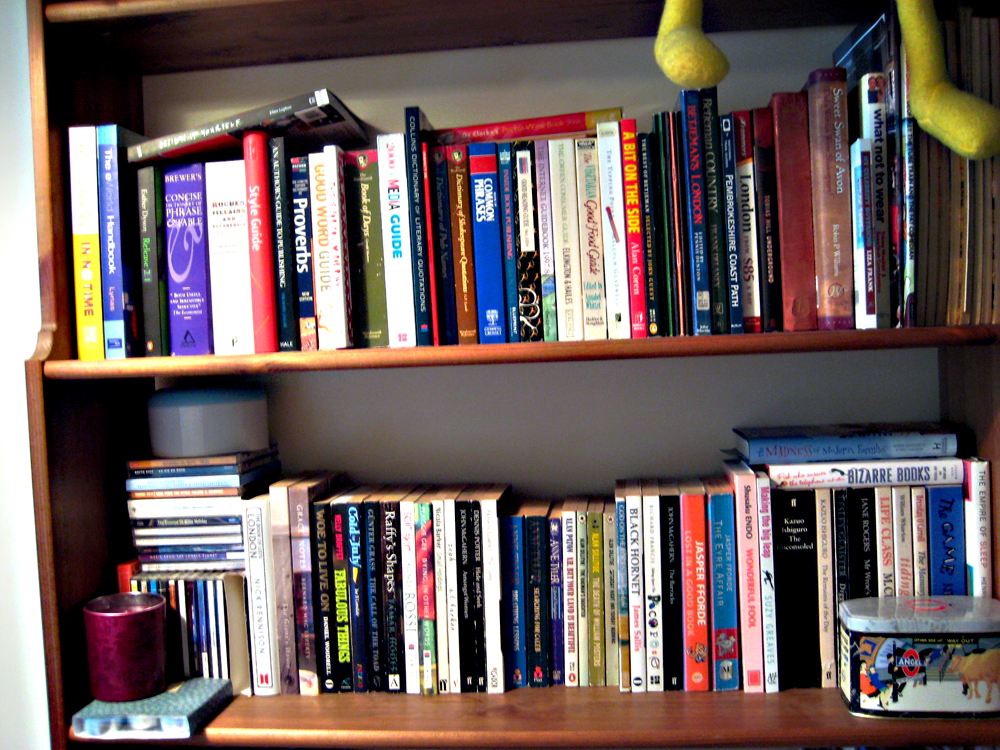 a book shelf full of various books and other stuff