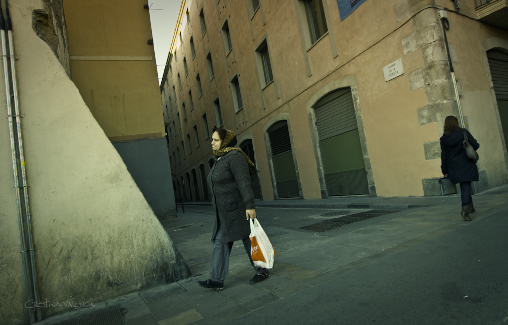 man in a suit walking down the street carrying a bag