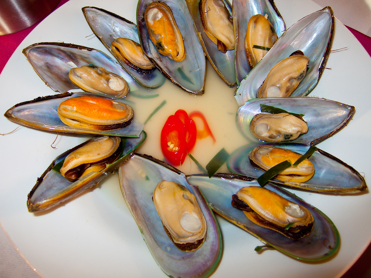 a plate full of cooked mussels and peppers