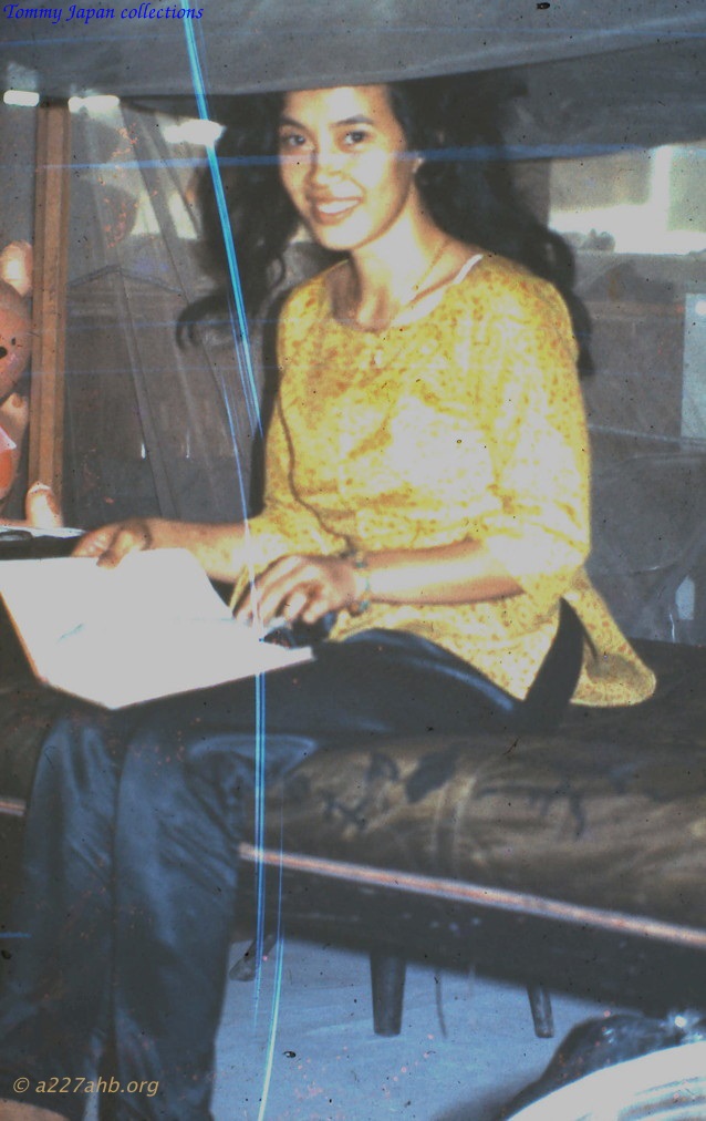 a woman sitting in bed while she holds a laptop