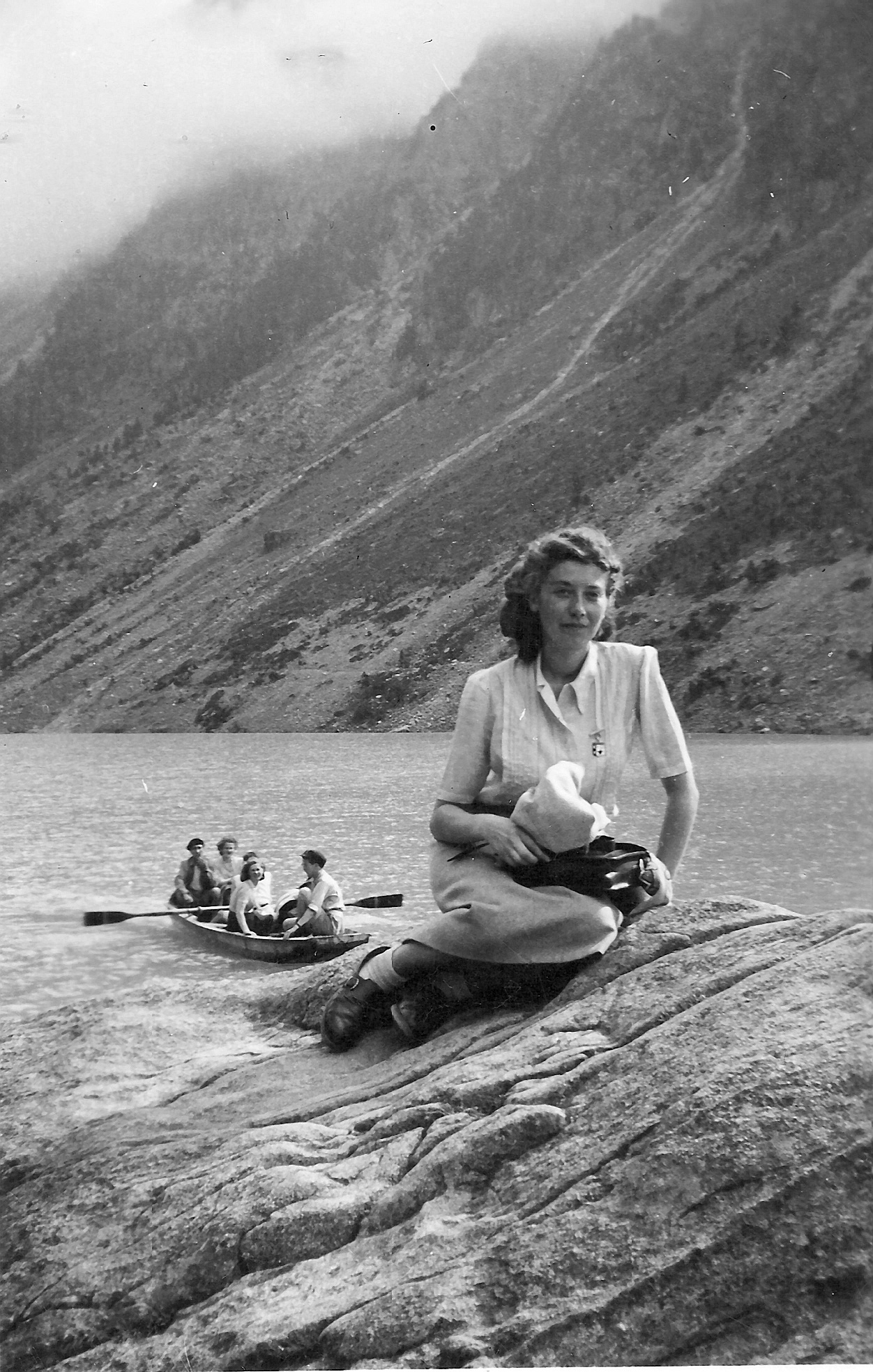 a woman sitting on the rocks in front of some water