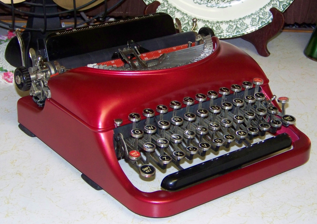 a red antique typewriter on a table