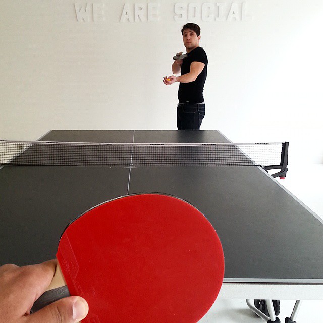 a ping pong table with a ping pong paddle held above it