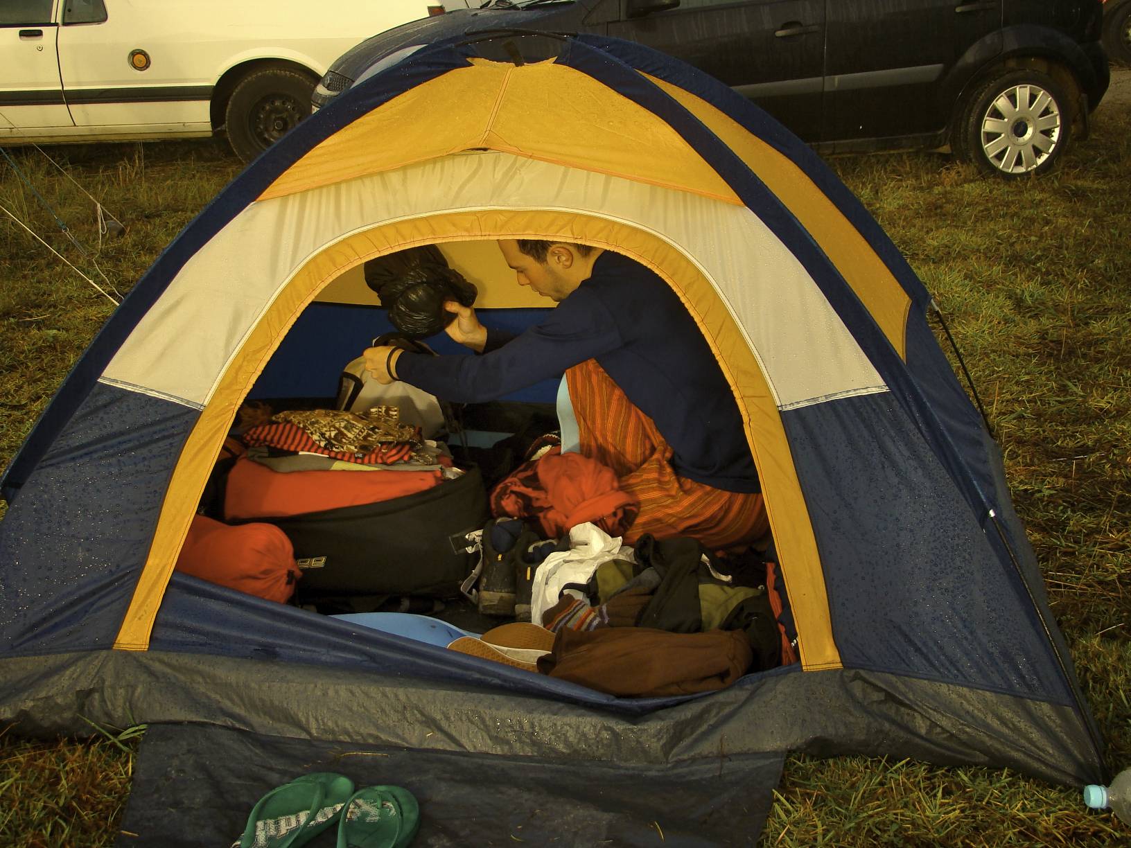 a man standing in the doorway of a tent with his luggage