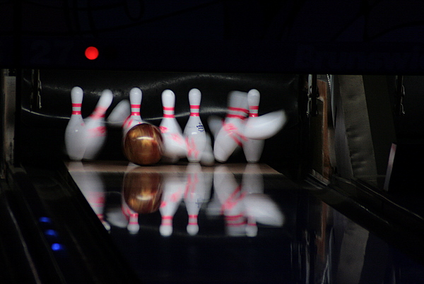 two bowling balls on the side of a bowling alley