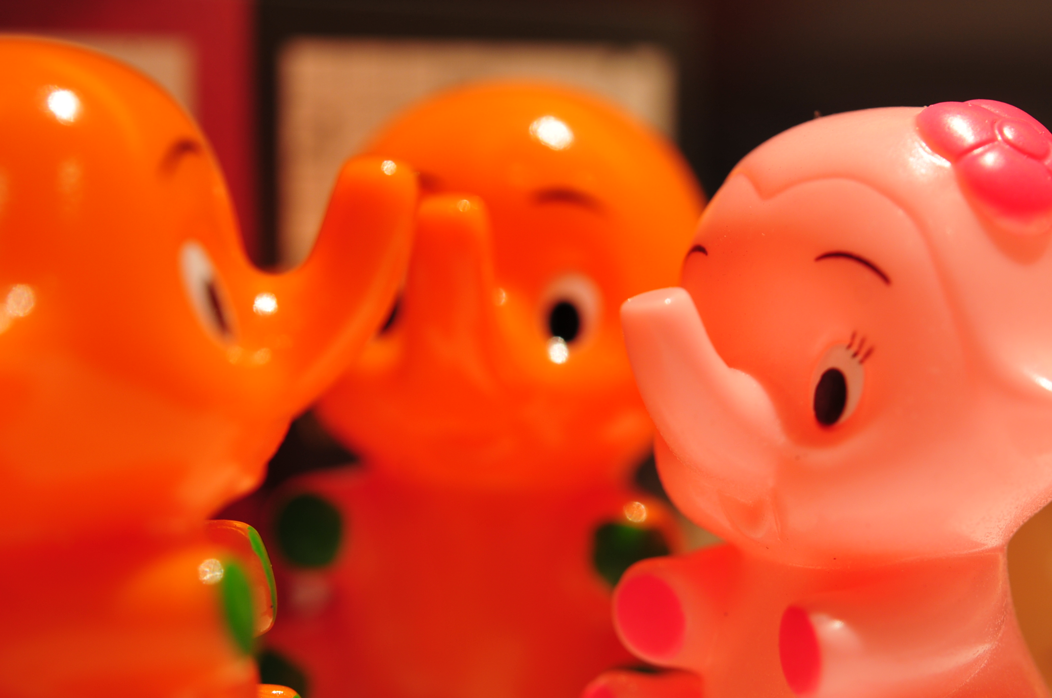 two pink and orange elephants are shown close together