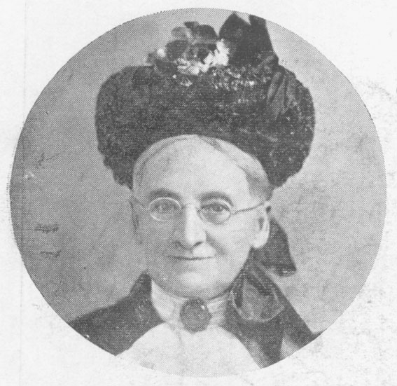 a woman with glasses wearing an afro hat and a blouse