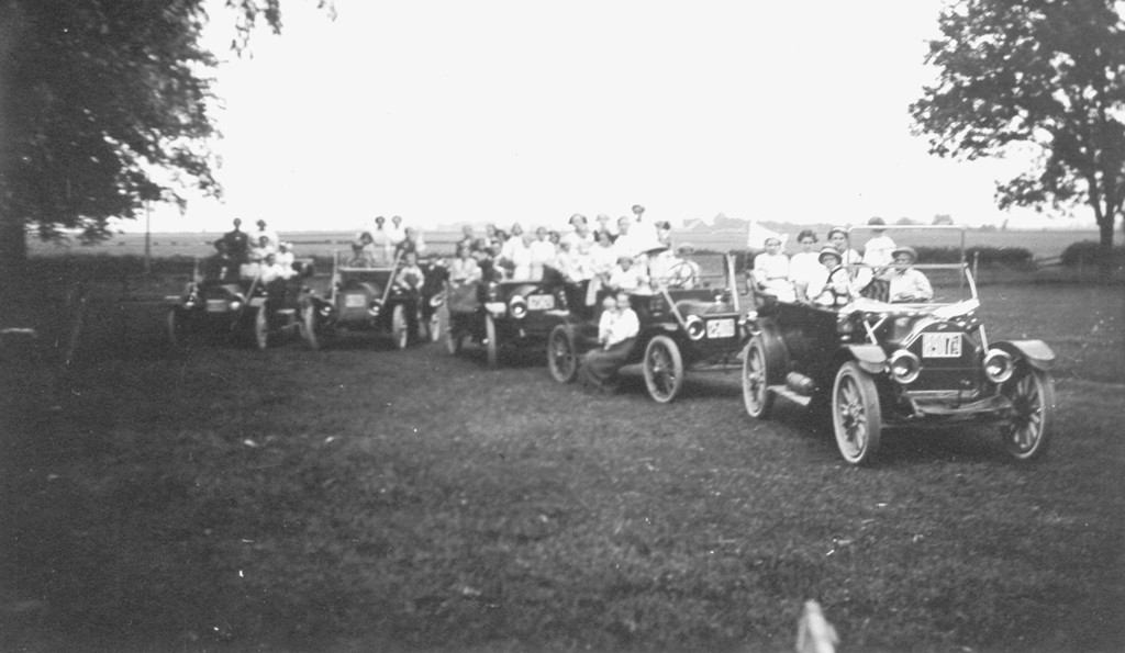 a group of people riding in a car with a horse on the back