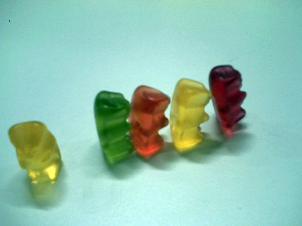 three gummy bears sitting on a table next to each other