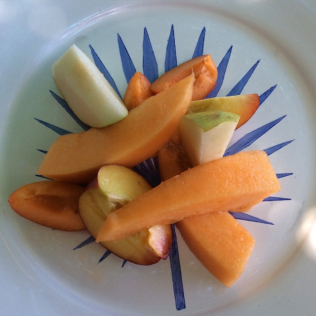 a group of oranges, apples and bananas on a plate
