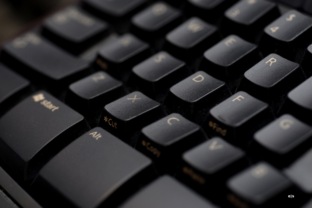 the front of a black keyboard has a golden d in it