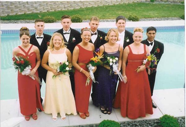 group of people in formal wear posing in front of water