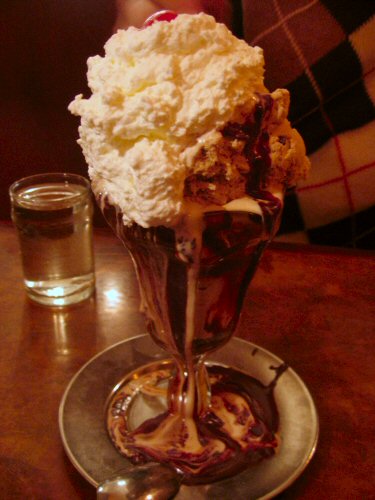 a cone of ice cream on top of a silver dish