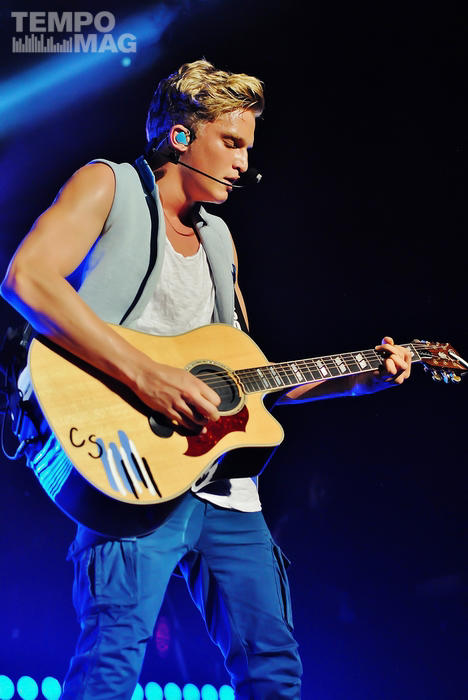 a man playing guitar on a stage