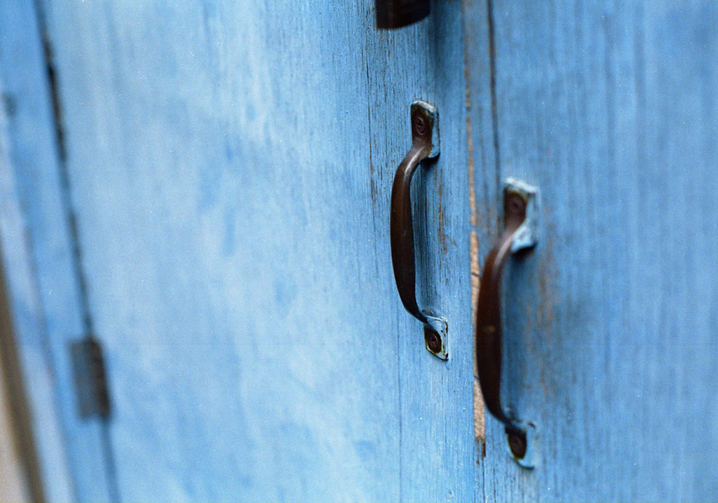 a blue door with ss handles and wooden handle s